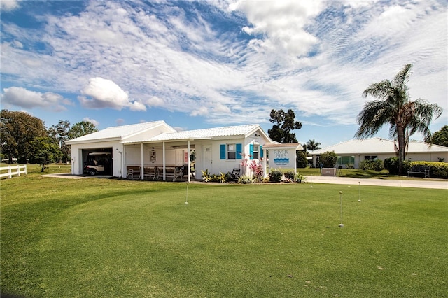 ranch-style home featuring a garage, covered porch, and a front yard