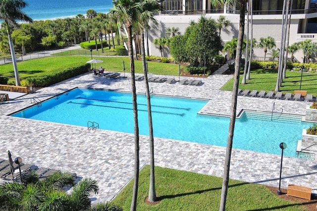 view of swimming pool with a water view and a yard