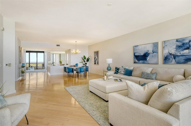 living room with a chandelier and light hardwood / wood-style flooring