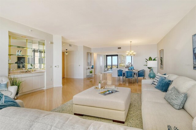 415 L Ambiance Dr Unit C703, Longboat Key, FL 34228 - living room featuring a chandelier and light wood-style floors