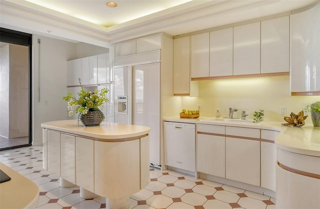 kitchen with dishwasher, a kitchen island, sink, and white cabinets