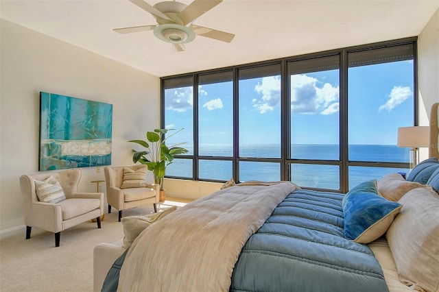 bedroom with a water view, multiple windows, and ceiling fan