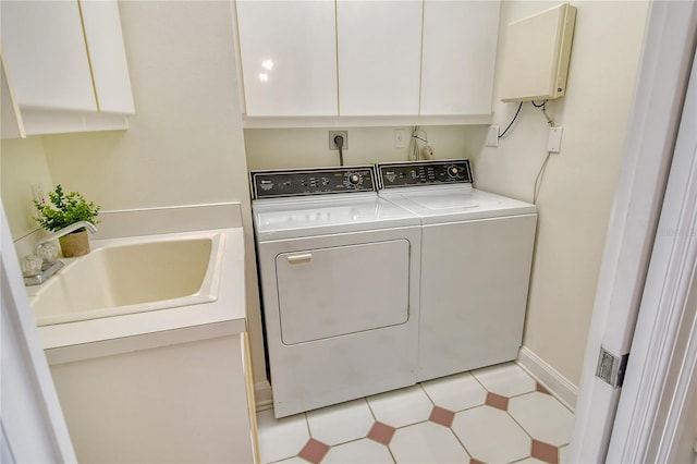 clothes washing area with sink, cabinets, and washing machine and clothes dryer