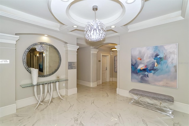 hall with ornamental molding, an inviting chandelier, and ornate columns