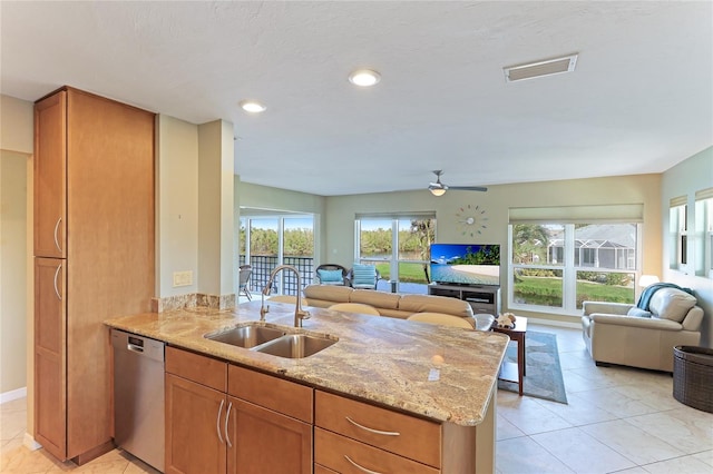 kitchen featuring light stone countertops, a healthy amount of sunlight, sink, and dishwasher