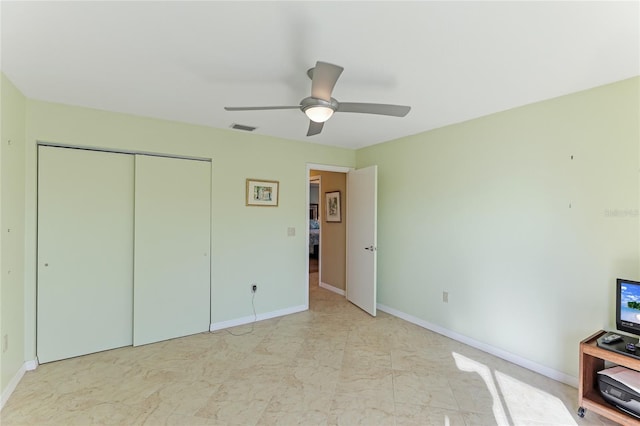 unfurnished bedroom featuring ceiling fan and a closet