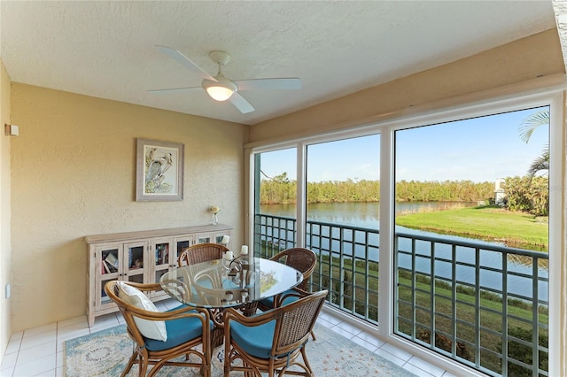 sunroom / solarium with a water view and ceiling fan