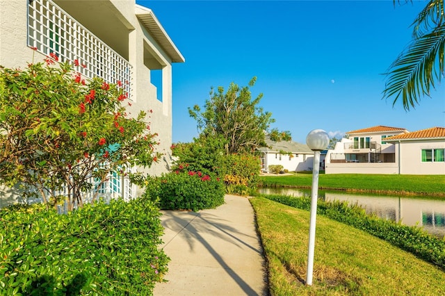 surrounding community featuring a lawn and a water view