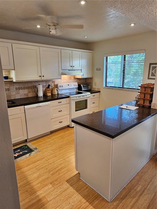 kitchen featuring white cabinets, light hardwood / wood-style floors, and white appliances