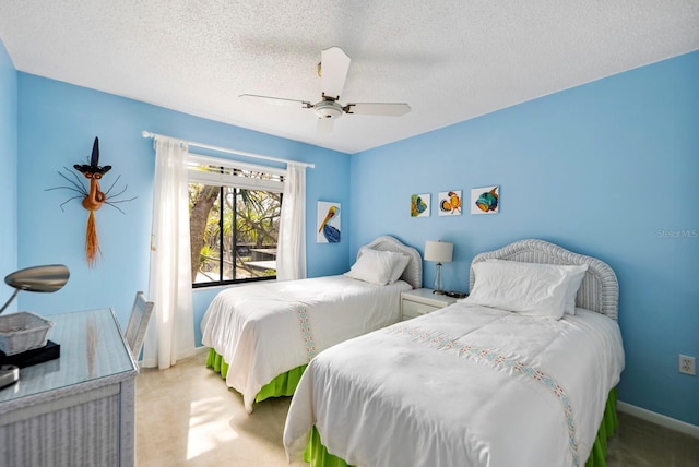 carpeted bedroom featuring a textured ceiling and ceiling fan