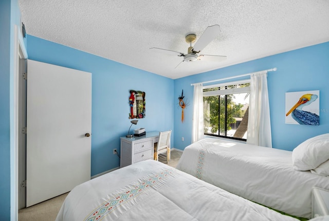 bedroom with ceiling fan, light colored carpet, and a textured ceiling