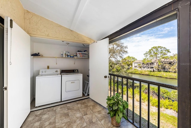 clothes washing area with washer and dryer and a water view