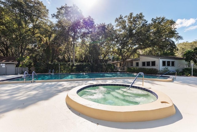 view of swimming pool featuring a hot tub