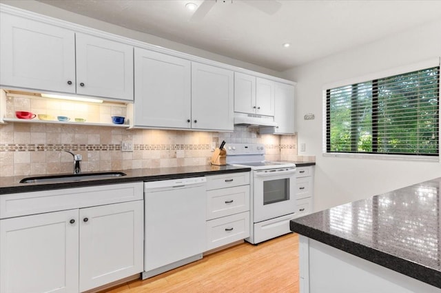 1519 Pelican Point Dr Unit 292, Sarasota, FL 34231 - kitchen featuring white appliances, under cabinet range hood, backsplash, white cabinetry, and light wood-type flooring