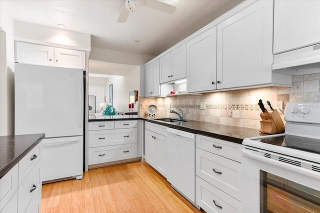 1519 Pelican Point Dr Unit 292, Sarasota, FL 34231 - kitchen featuring white appliances, premium range hood, dark countertops, a ceiling fan, and light wood-type flooring