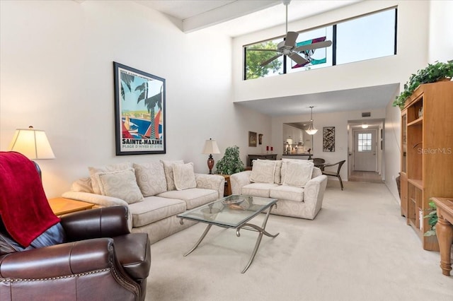 1519 Pelican Point Dr Unit 292, Sarasota, FL 34231 - living room featuring a ceiling fan, healthy amount of natural light, light colored carpet, and a towering ceiling