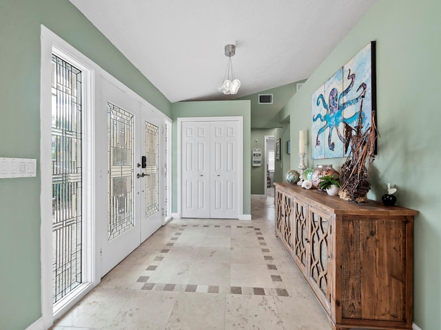 doorway featuring a chandelier, french doors, and vaulted ceiling