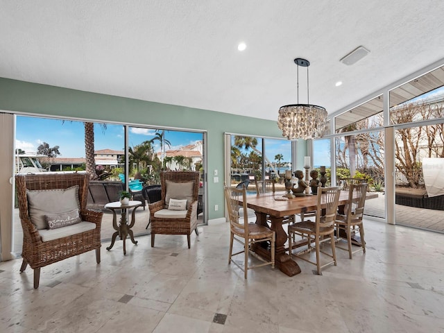 dining space featuring a textured ceiling, an inviting chandelier, and a wealth of natural light