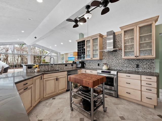 kitchen with sink, wall chimney exhaust hood, stainless steel appliances, backsplash, and kitchen peninsula