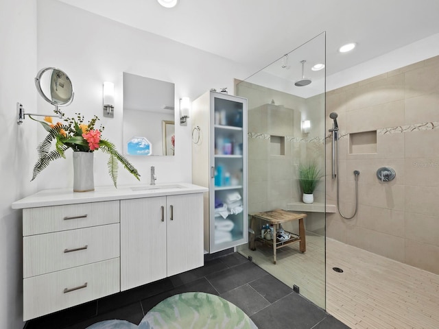 bathroom with a tile shower, tile patterned floors, and vanity