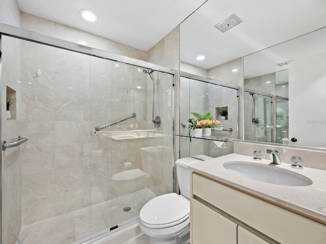 bathroom featuring walk in shower, vanity, and toilet