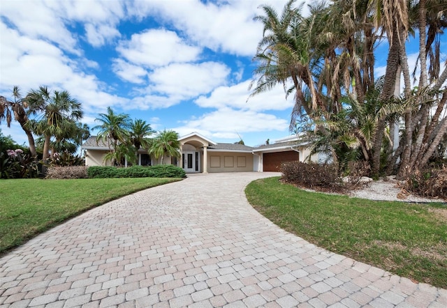 ranch-style house featuring a front lawn and a garage