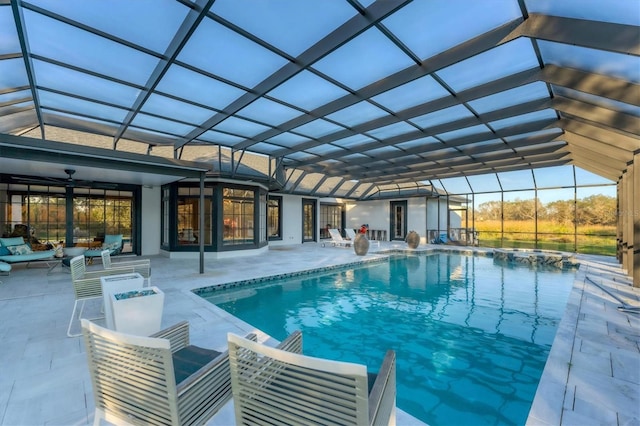 view of swimming pool with ceiling fan, an outdoor living space, a lanai, and a patio area