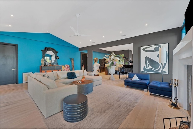 living room featuring vaulted ceiling, light hardwood / wood-style floors, and ceiling fan