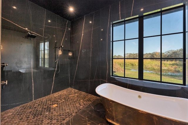 bathroom featuring shower with separate bathtub and tile walls