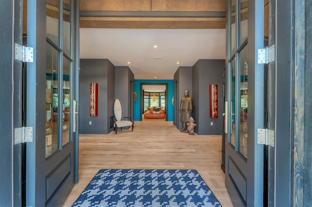 hall with french doors and light wood-type flooring