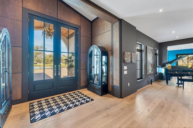 foyer entrance featuring plenty of natural light, french doors, and light wood-type flooring