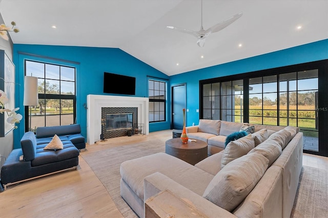 living room featuring lofted ceiling, ceiling fan, and light hardwood / wood-style flooring