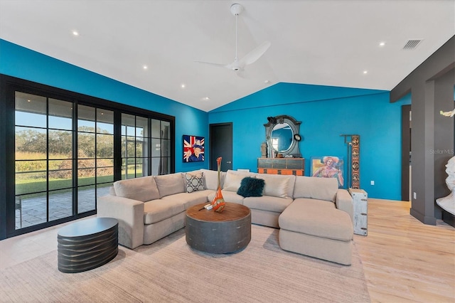 living room featuring vaulted ceiling, ceiling fan, and light wood-type flooring