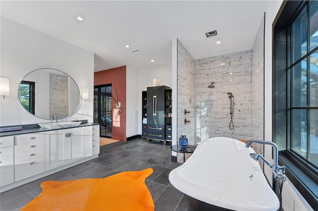 bathroom featuring tile patterned floors, vanity, and a washtub