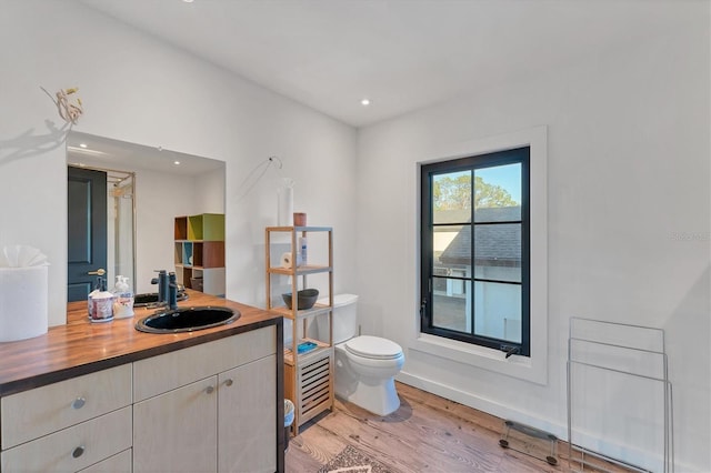 bathroom featuring hardwood / wood-style flooring, vanity, and toilet