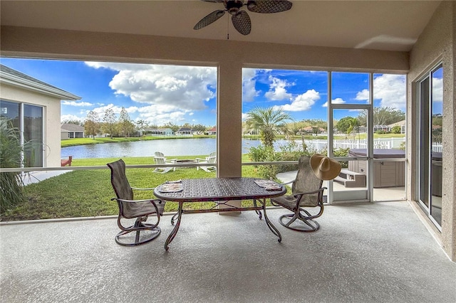 sunroom / solarium with a water view and ceiling fan