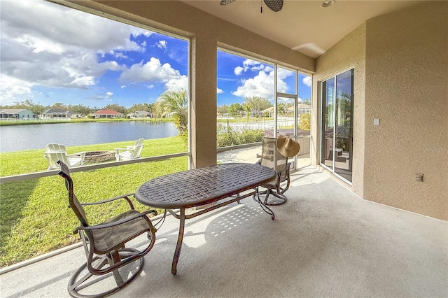 sunroom featuring a water view