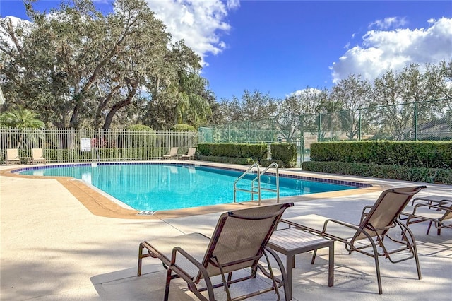 community pool featuring a patio and fence