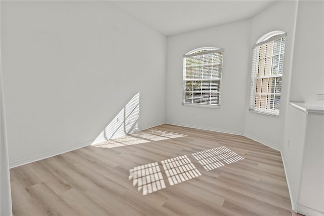 unfurnished room featuring light wood-type flooring and baseboards