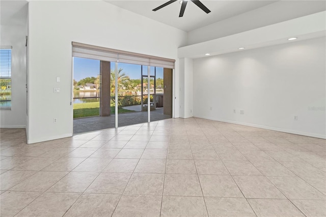 unfurnished room with tile patterned floors, a healthy amount of sunlight, baseboards, and a ceiling fan