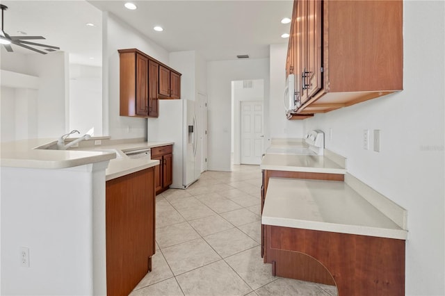 kitchen featuring light tile patterned flooring, white appliances, light countertops, and a sink