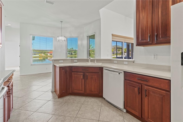 kitchen with white appliances, light countertops, a peninsula, and a sink