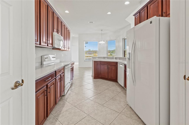 kitchen featuring white appliances, light tile patterned floors, a peninsula, a sink, and light countertops