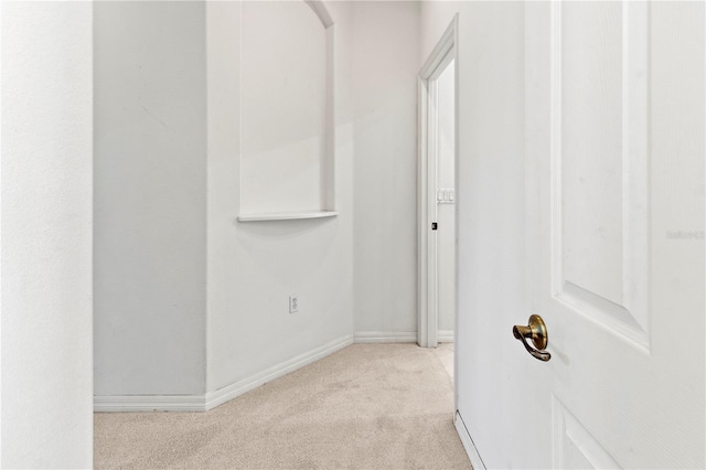 hallway featuring baseboards and carpet floors