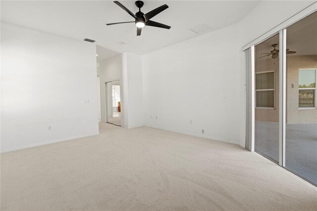 empty room with visible vents, light carpet, baseboards, and ceiling fan