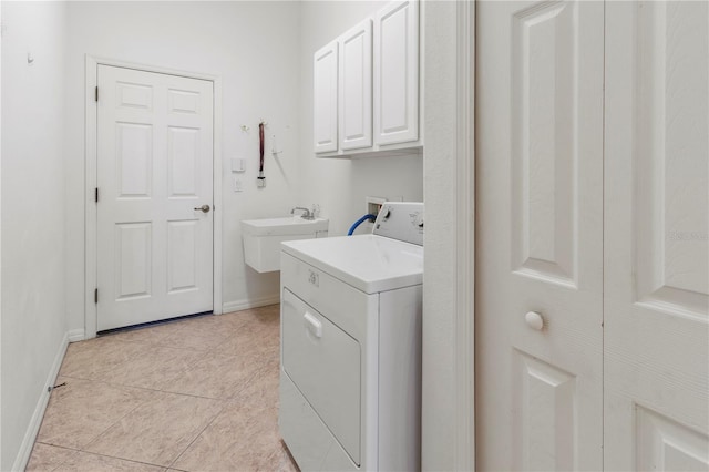 laundry area featuring baseboards, light tile patterned floors, washer / dryer, cabinet space, and a sink