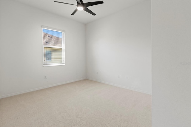 carpeted spare room with baseboards and ceiling fan