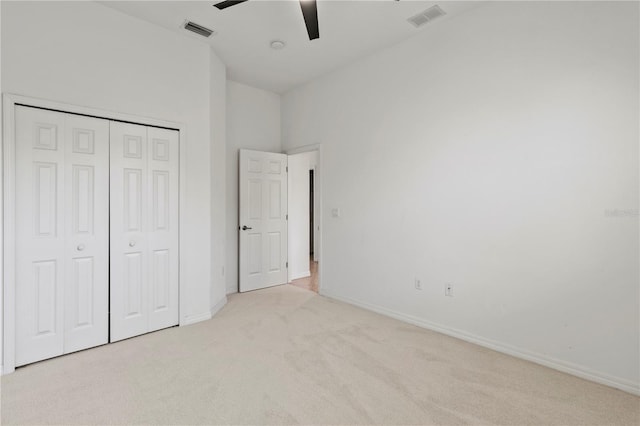 unfurnished bedroom featuring light carpet, visible vents, baseboards, and a closet