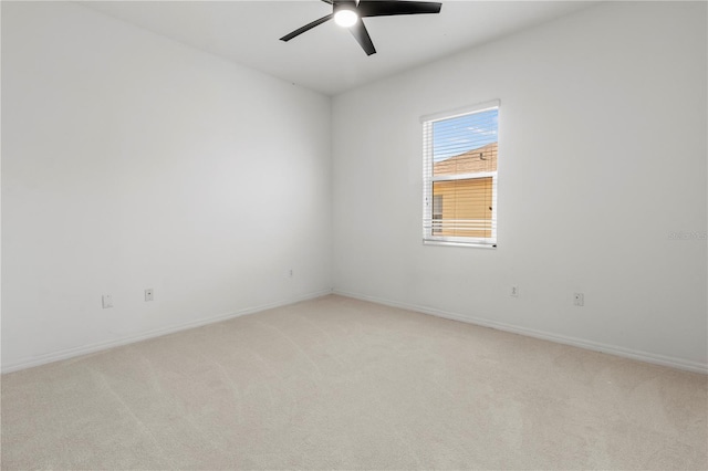 spare room with baseboards, light carpet, and ceiling fan