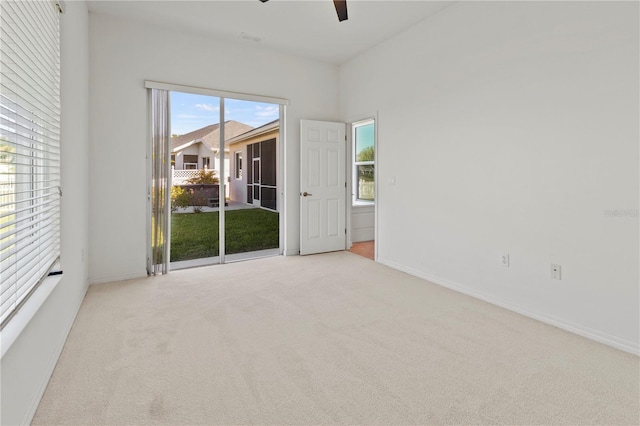 carpeted empty room with a ceiling fan and baseboards